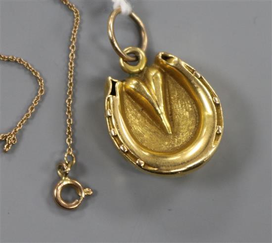An 18ct gold horseshoe locket, on an 8ct gold fine link chain, locket 21mm.